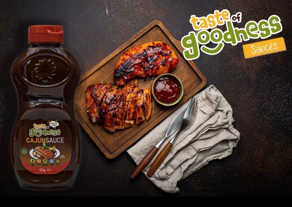 bottle of taste of goodness cajun sauce with cajun chicken in the background