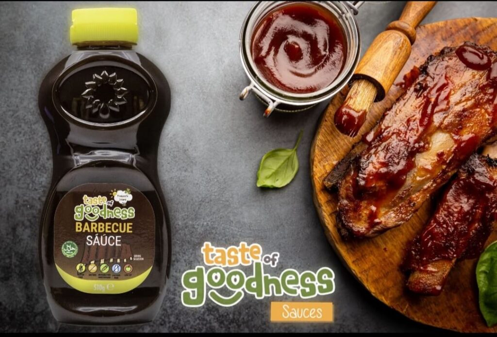 Bottle of taste of goodness barbeque sauce with pork rib and dip alongside