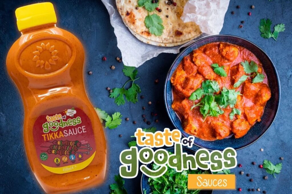 bottle of taste of goodness tikka sauce with background of a chicken tikka masala
