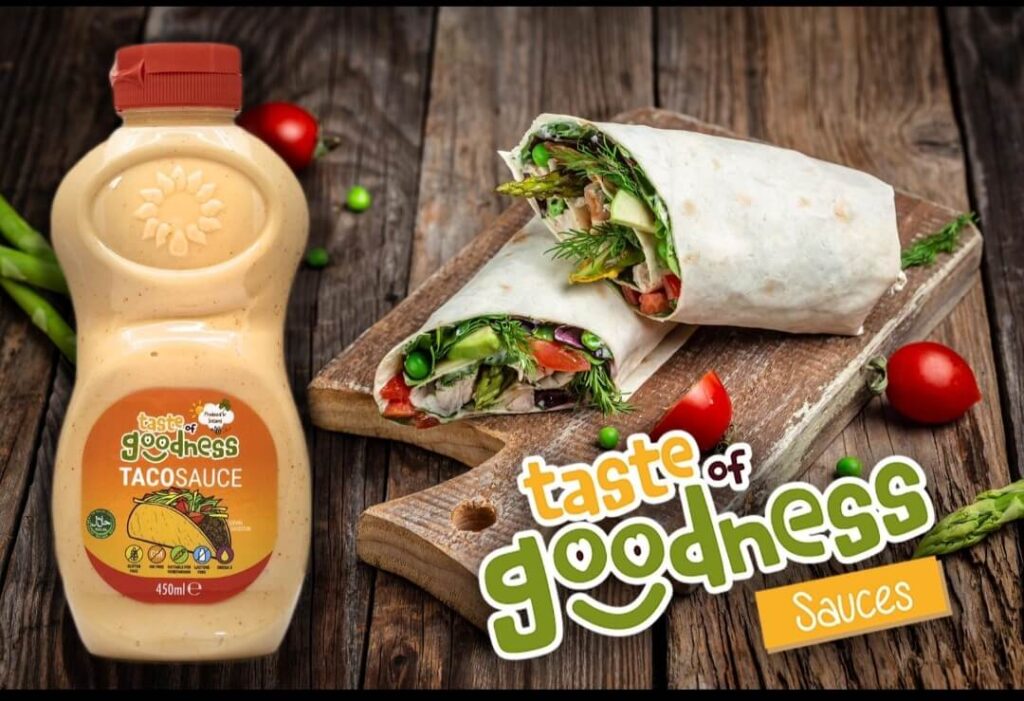 bottle of taste of goodness taco sauce with a wrap in the background